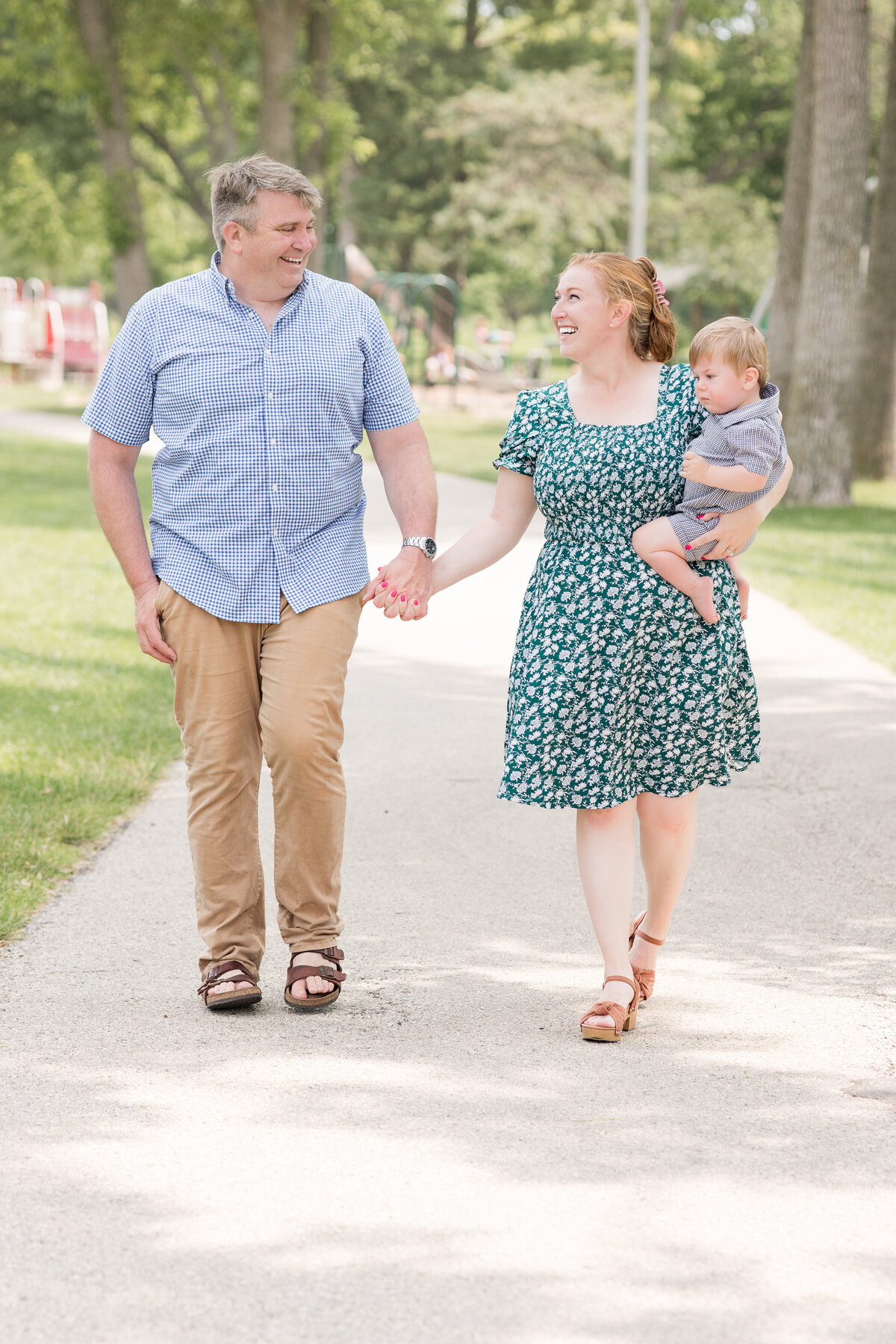 A family walks along a pathway smiling at each other
