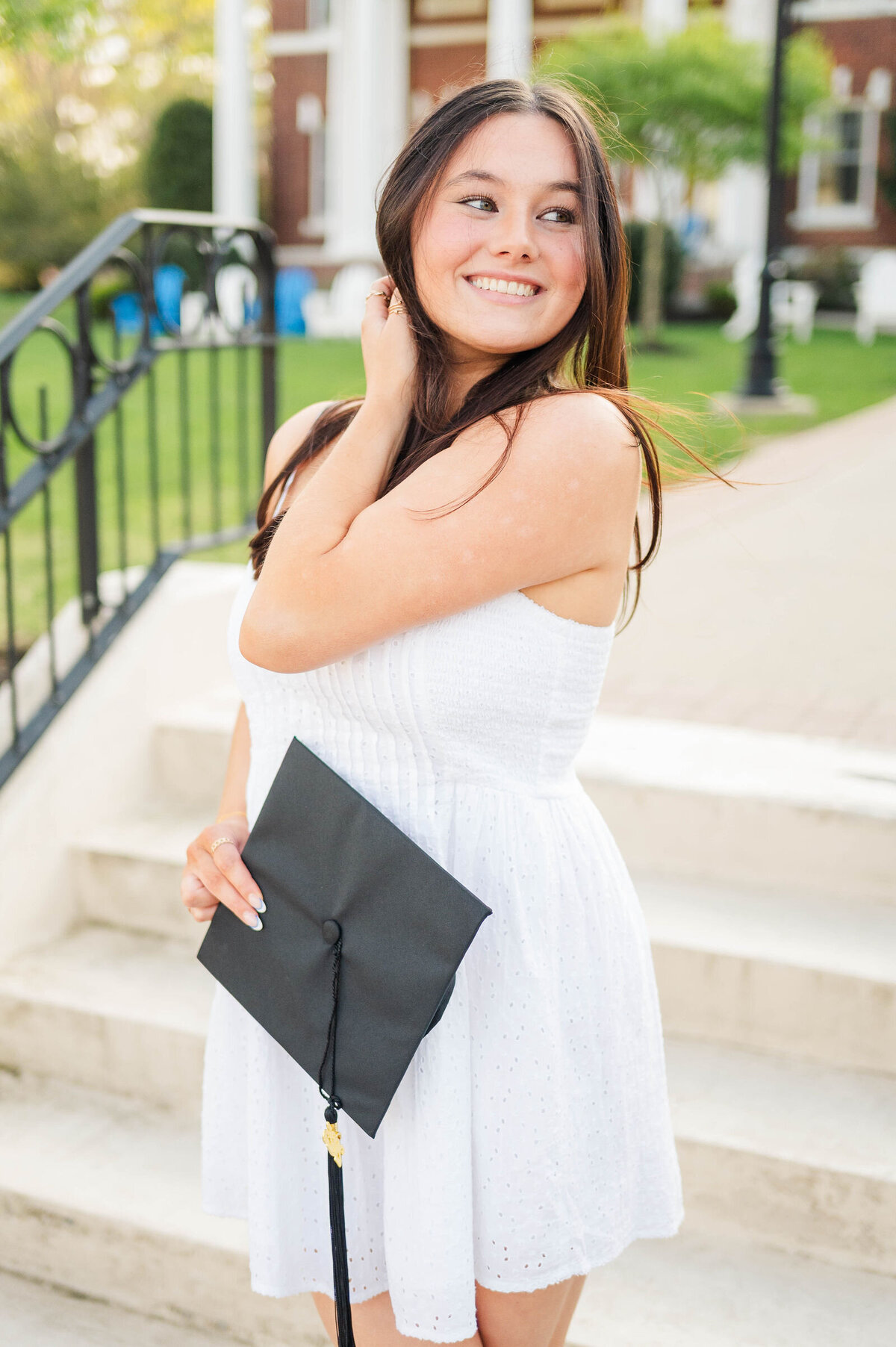 Cute grad holding her cap at Assumption University taken by best college grad photographer in Worcester, MA
