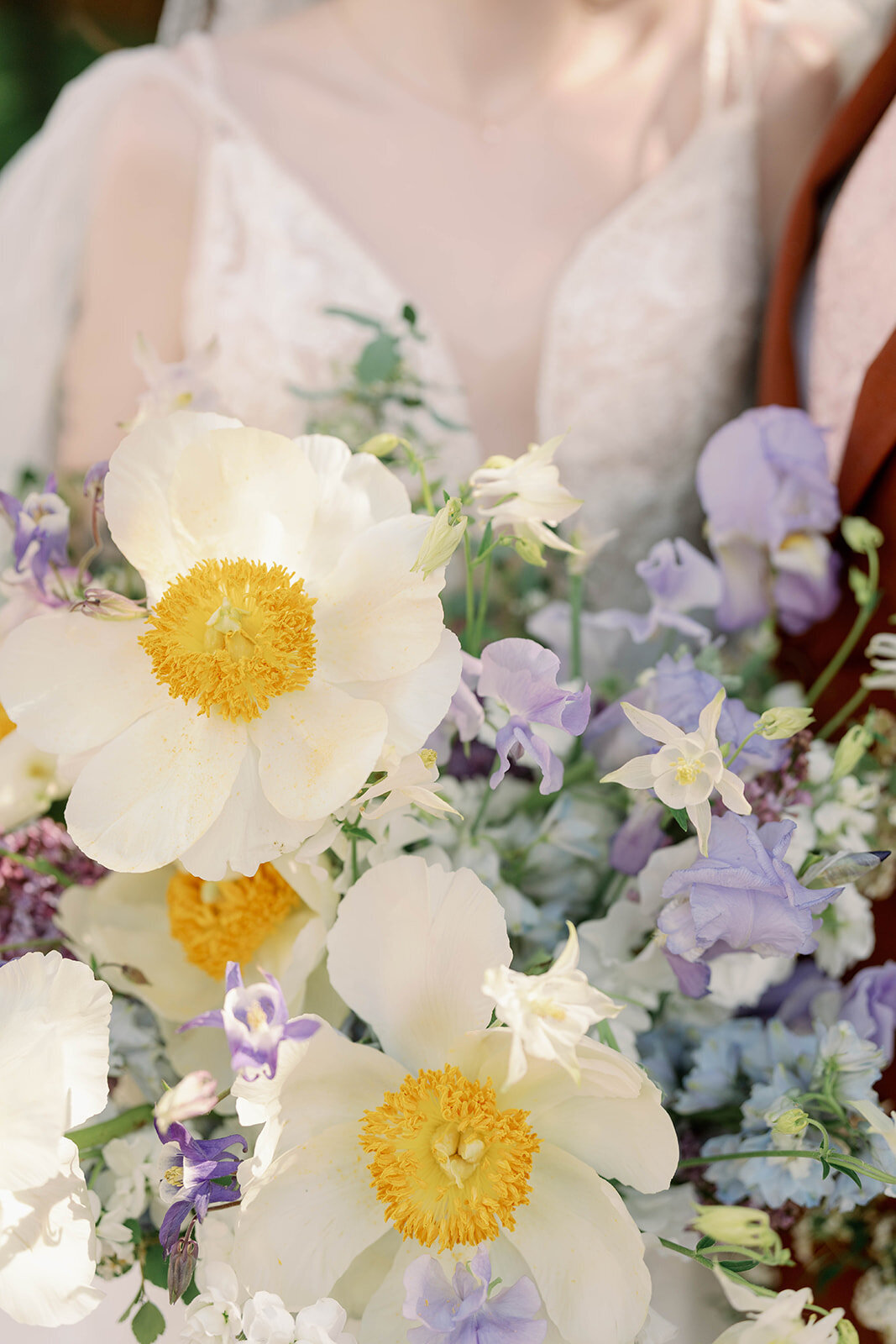 Close-up of colorful spring wedding bouquet with white and yellow blooms photographed in natural light