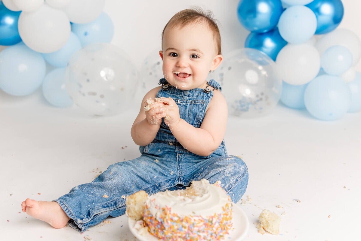 portland baby boy with cake on his face for first birthday pictures in portland