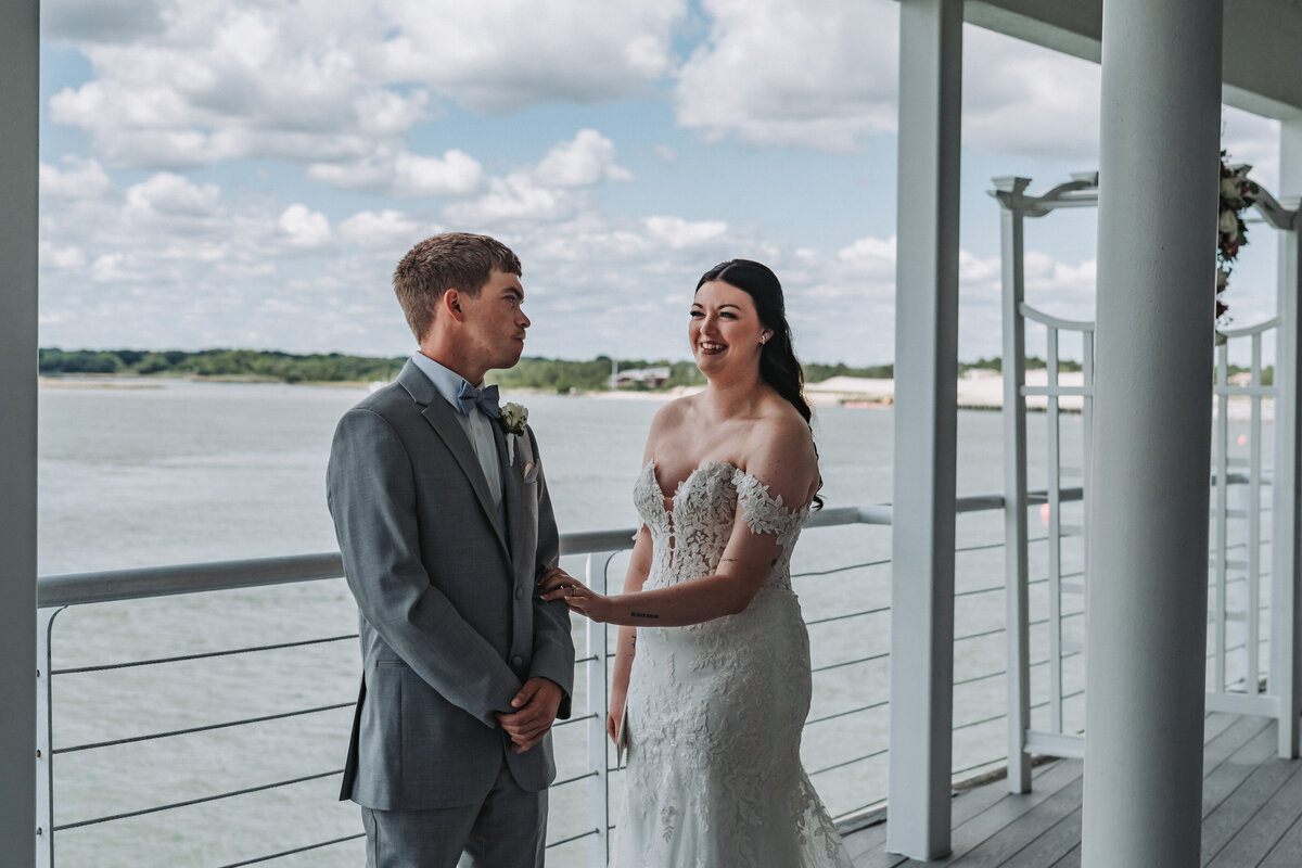 Bride and groom share a sweet first look on the balcony of the Lesner Inn overlooking the water in Virginia Beach, Virginia.