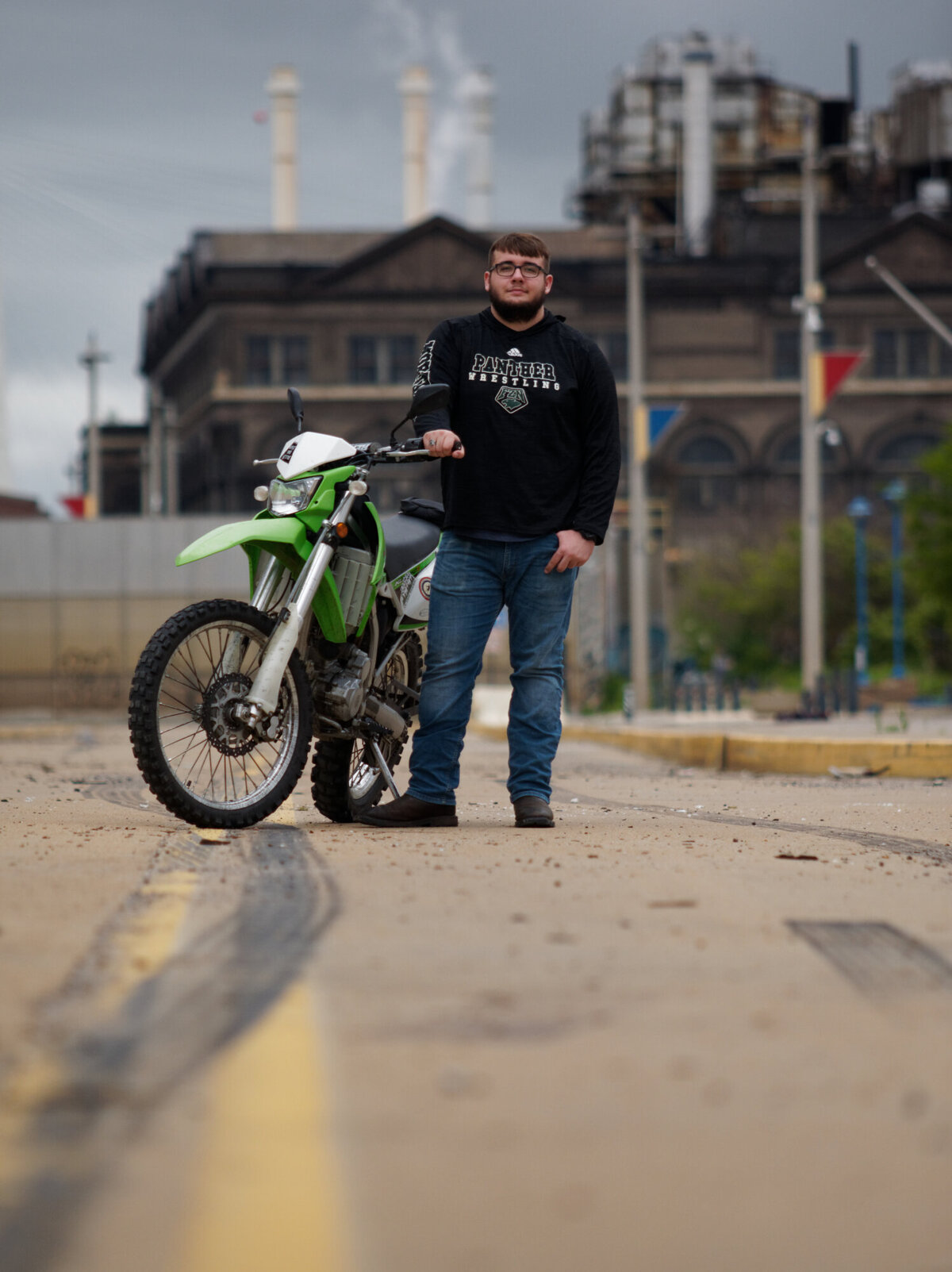 guy in urban environment with motorcycle  outside daytime portrait