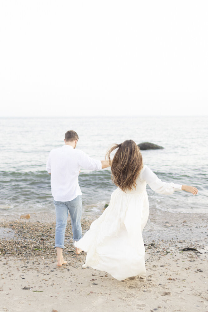 couple running on the beach together, Harkness Park engagement session