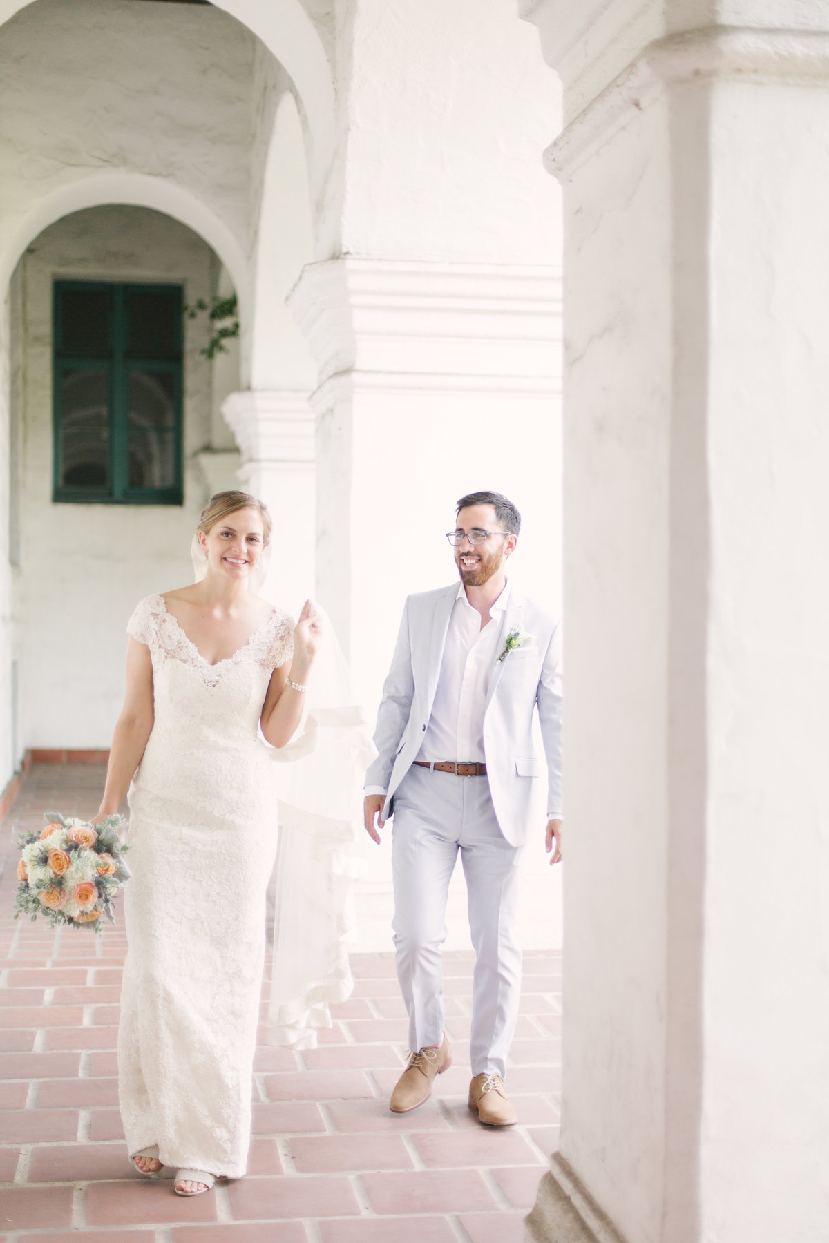 Bride and groom walk down hallway at Santa Barbara Courthouse wedding