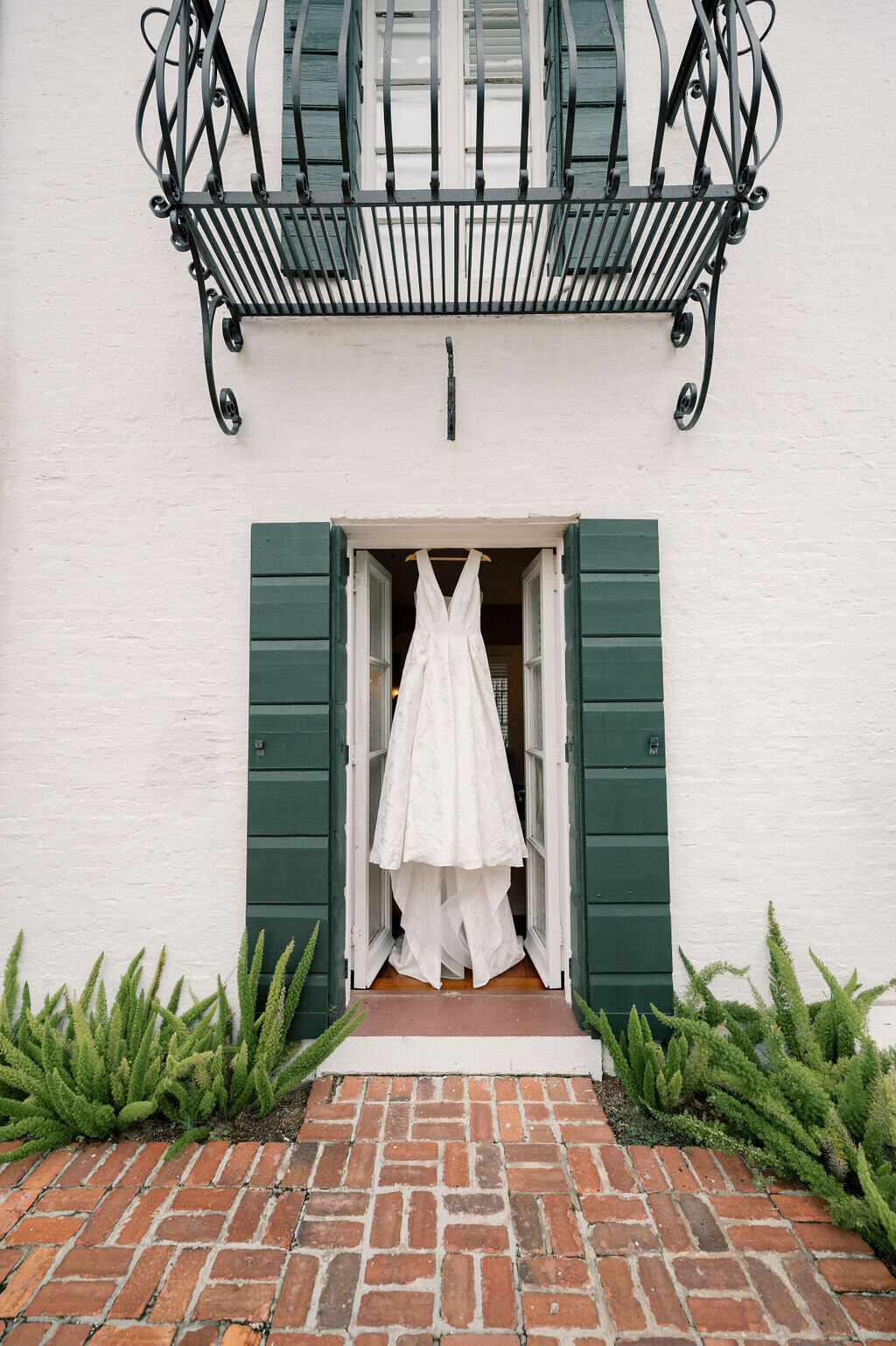 photo of brides dress hanging from the venue door taken by Jekyll Island Wedding Photographer, Rhonda Rowell