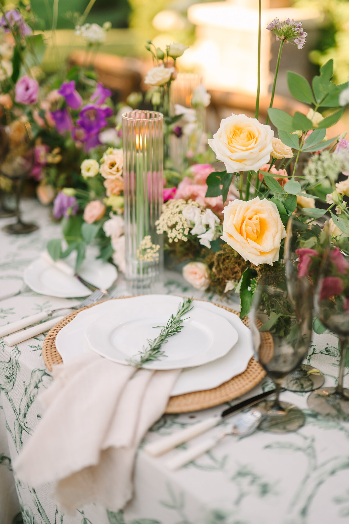 china and elegant glassware set on a  beautiful outdoor table with roses and wildflowers at Willowbrook wedding venue