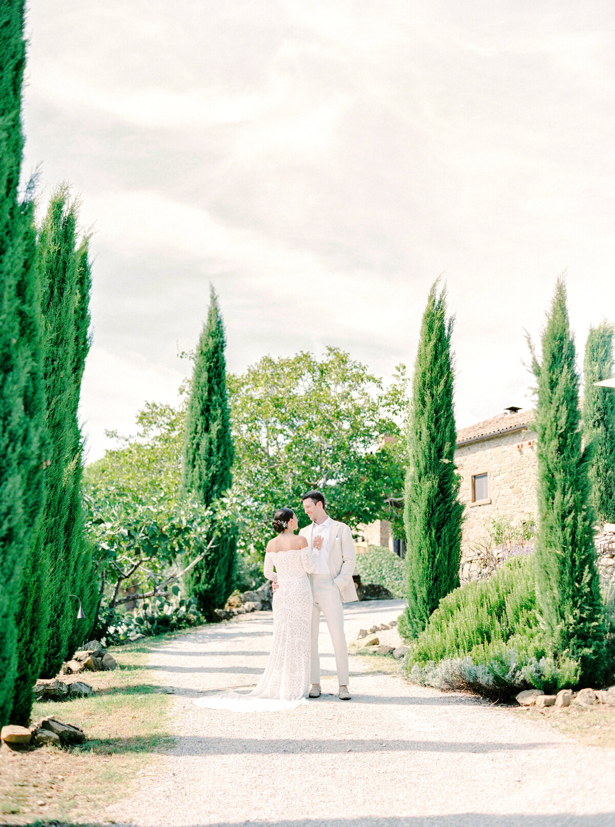 Film photograph of Bride and groom along cypress trees photographed by Italy wedding photographer at Villa Montanare Tuscany wedding
