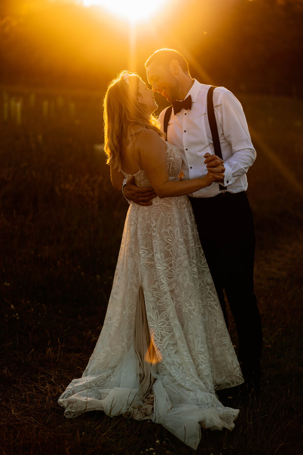 Bride and groom dance together in the golden sunlight at Broughton Sanctuary