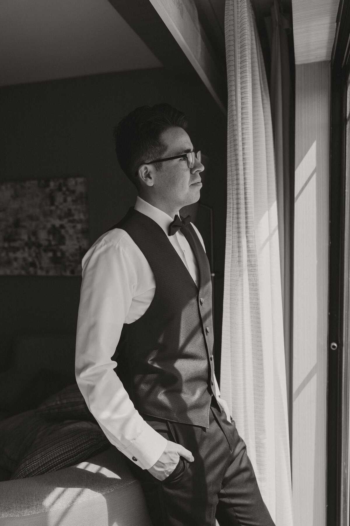 groom looking out the window, groom getting ready