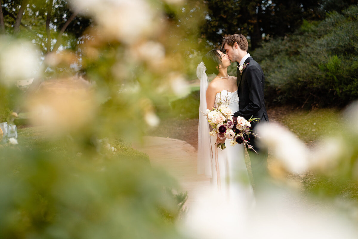 Bride and Groom newlyweds share a kiss during their outdoor candids, perfectly captured by Tanya Parada.