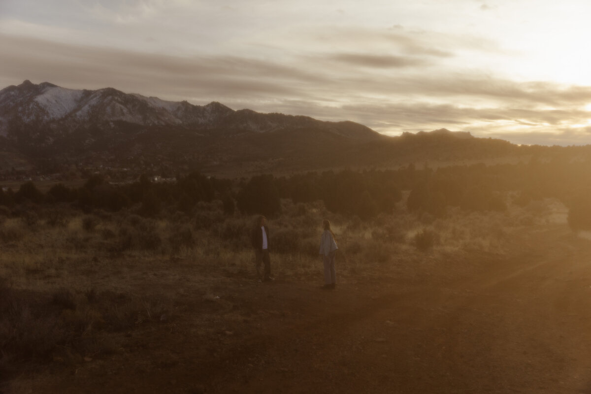 Moody Wide Angle Photo of Couple Playing the the Dirt in the Mountains 