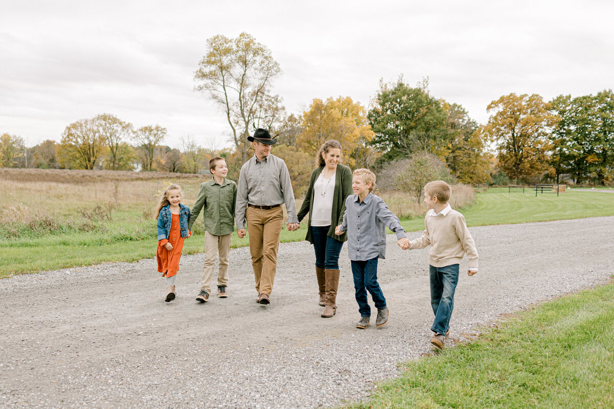family holding hands and walking on a gravel road