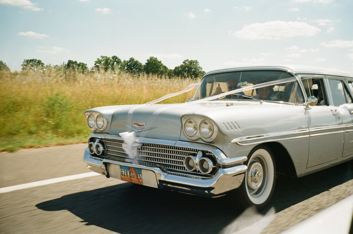 classic car driving to wedding ceremony