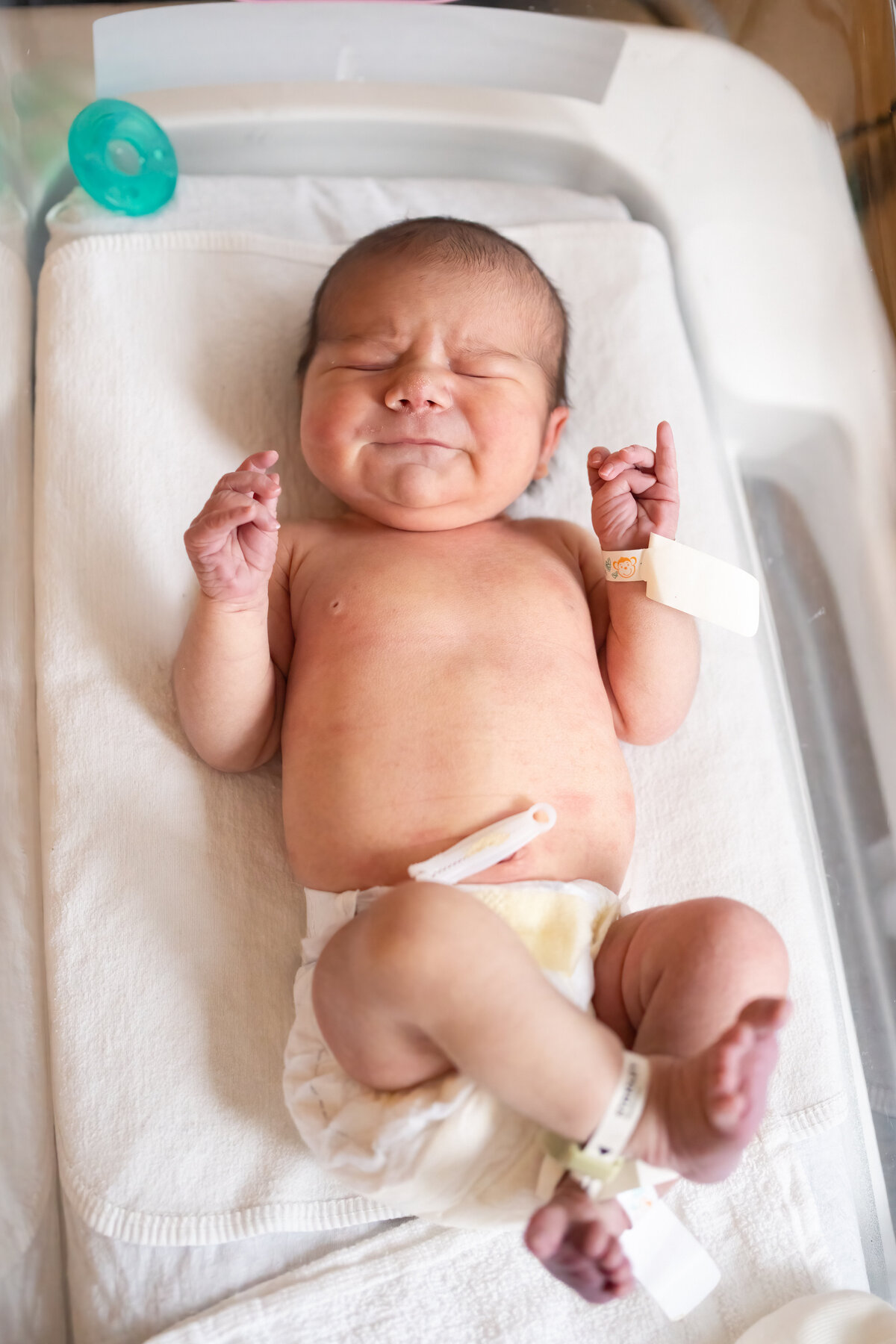 Baby in diaper laying in bassinet