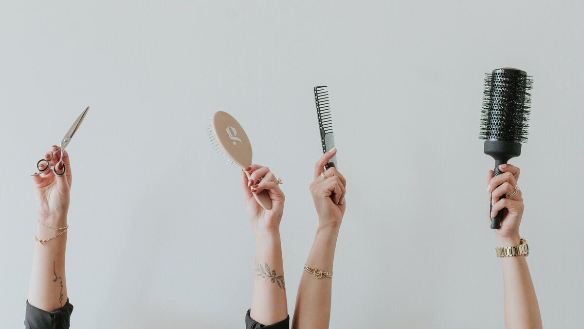 hands-holding-hair-tools-in-the-air-for-salon-brand-session-south-charlotte