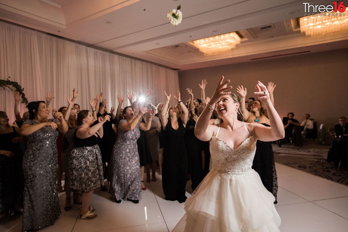 Bride tosses the bouquet to ladies in waiting