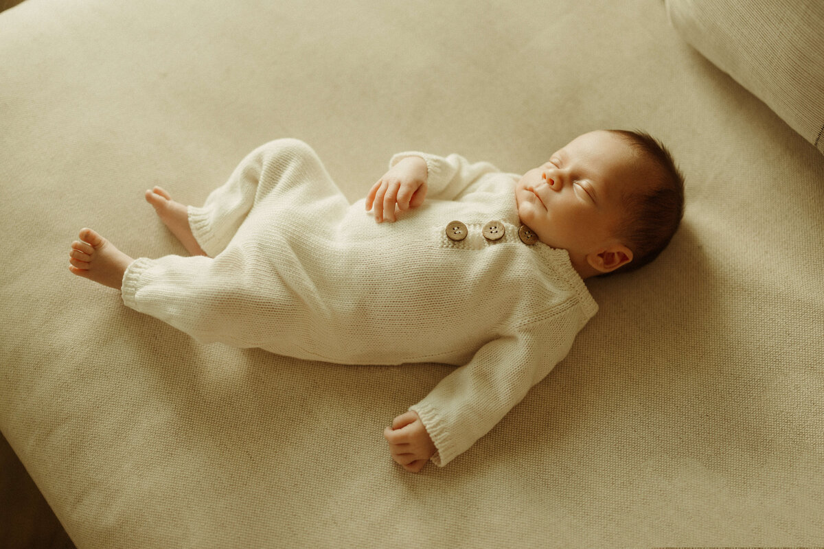 Newborn wrapped in white swaddle on bed in Franklin TN home