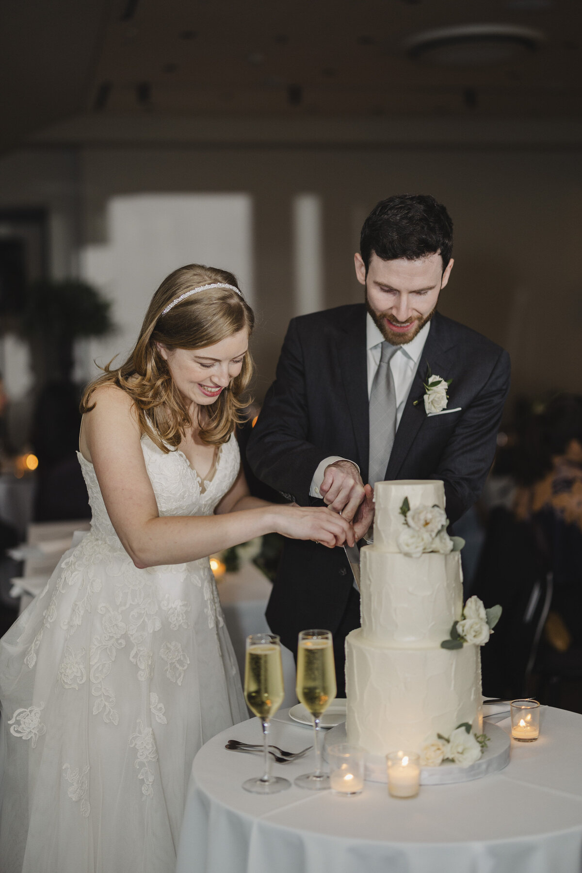 A newlywed couple cutting their wedding cake 