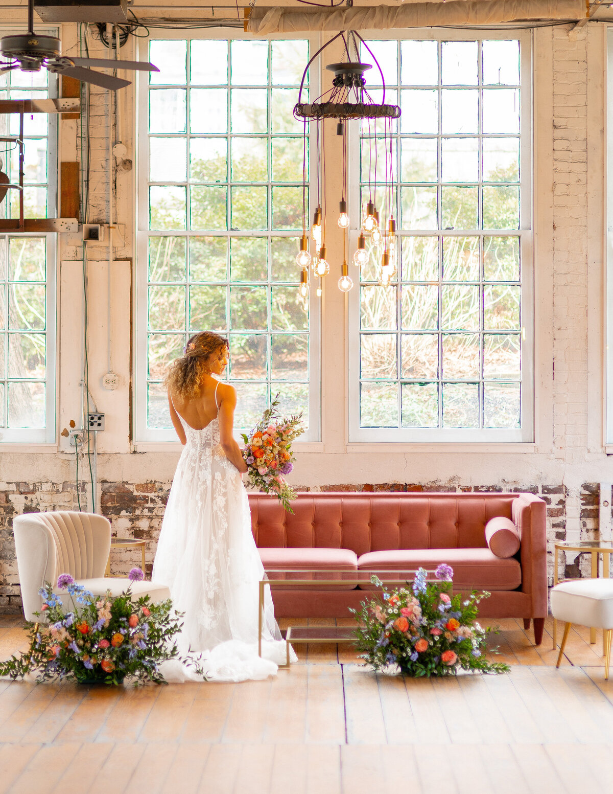 Bride standing by pink velvet couch