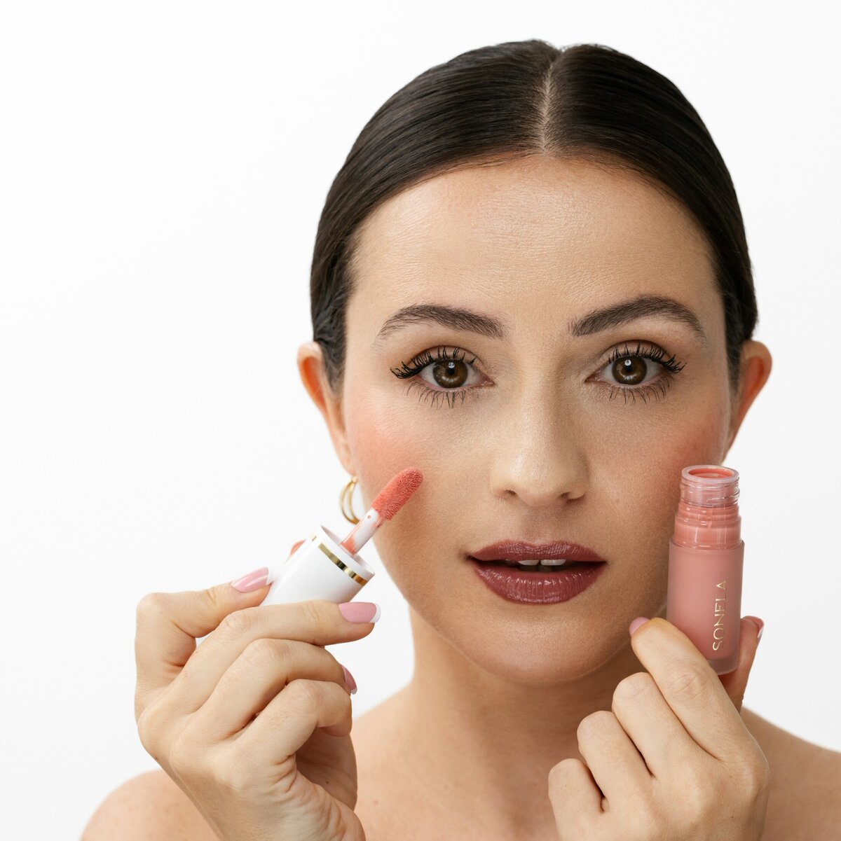 Model applying a Sonela Beauty product — showcasing clean luxury makeup