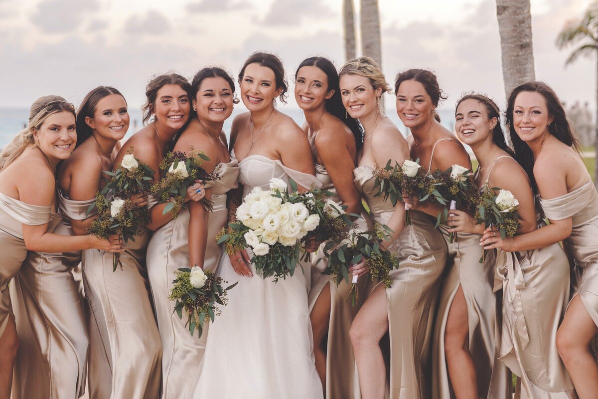 Bridesmaids cuddling and laughing at wedding in Cancun