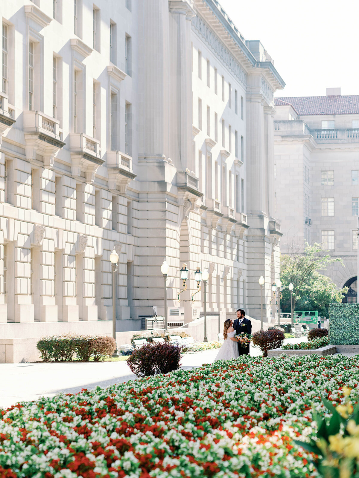 Bride and groom share a moment at a garden  in the city