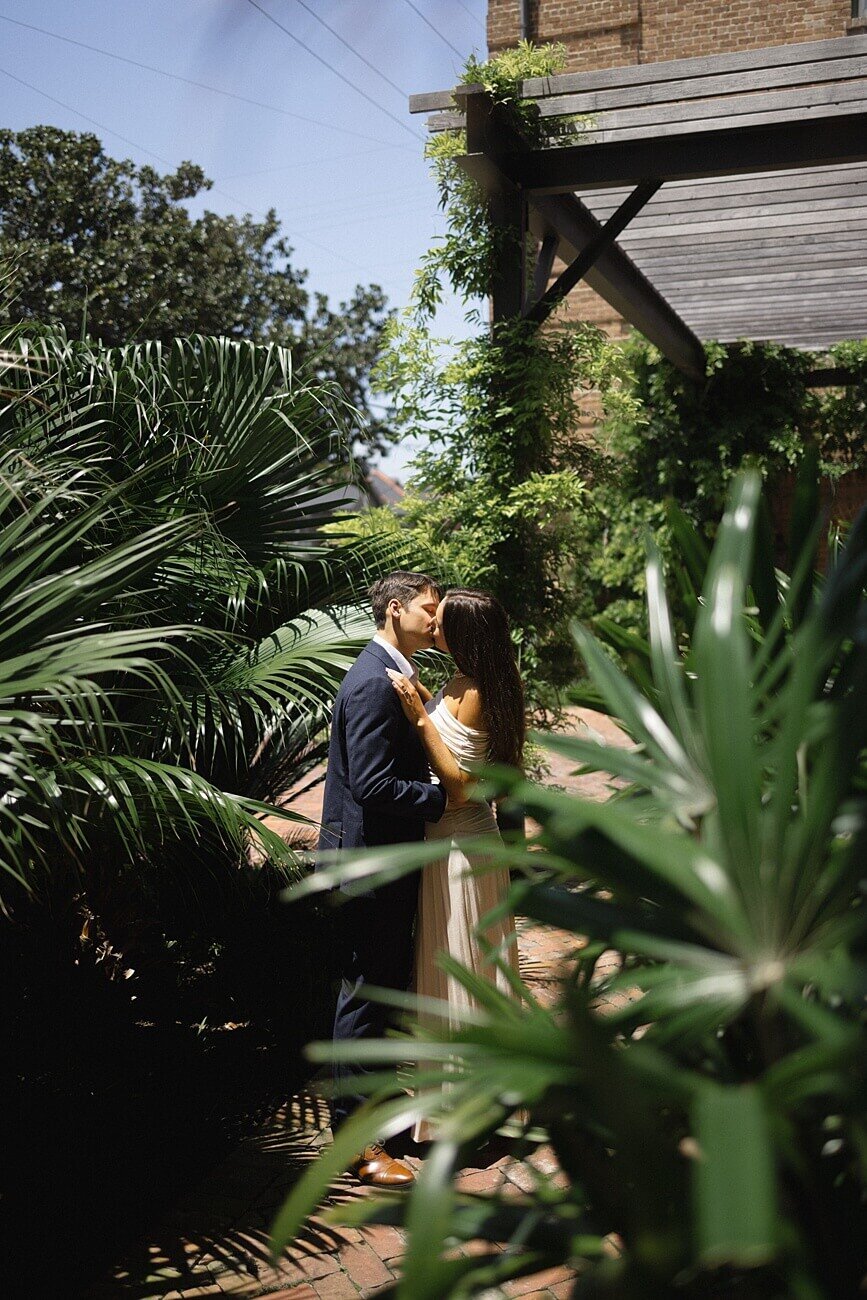 Couple sharing a kiss under pergola at Hotel Peter and Paul