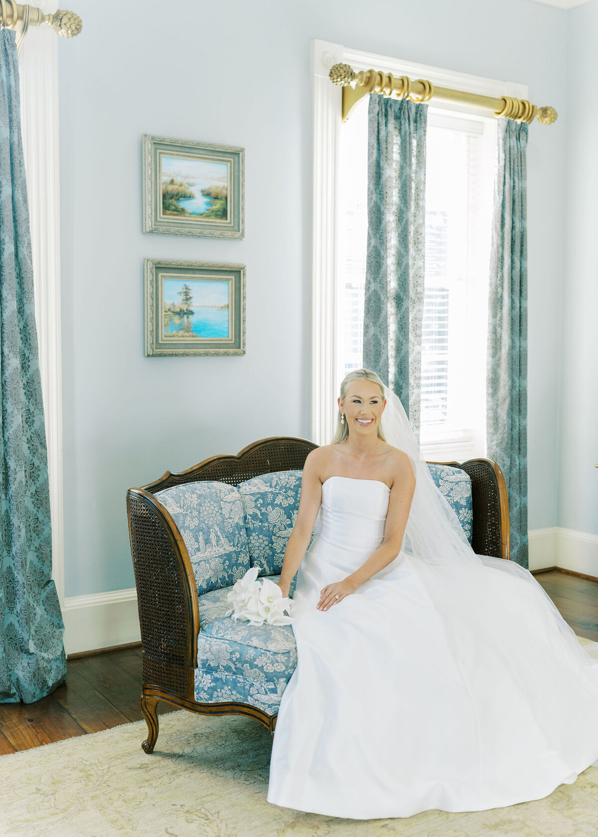 a bride sitting on a blue couch in her dress