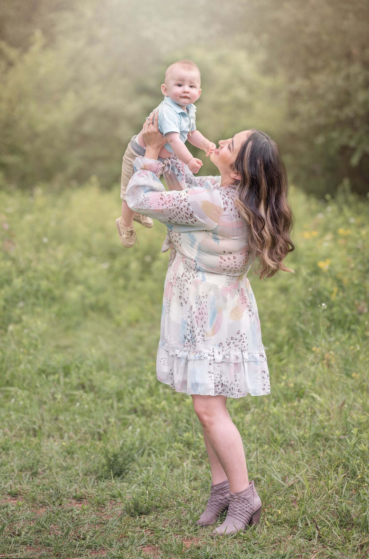 mom and baby playing airplane on field during a summer family session by woodstock family photographer elizabeth klusmann