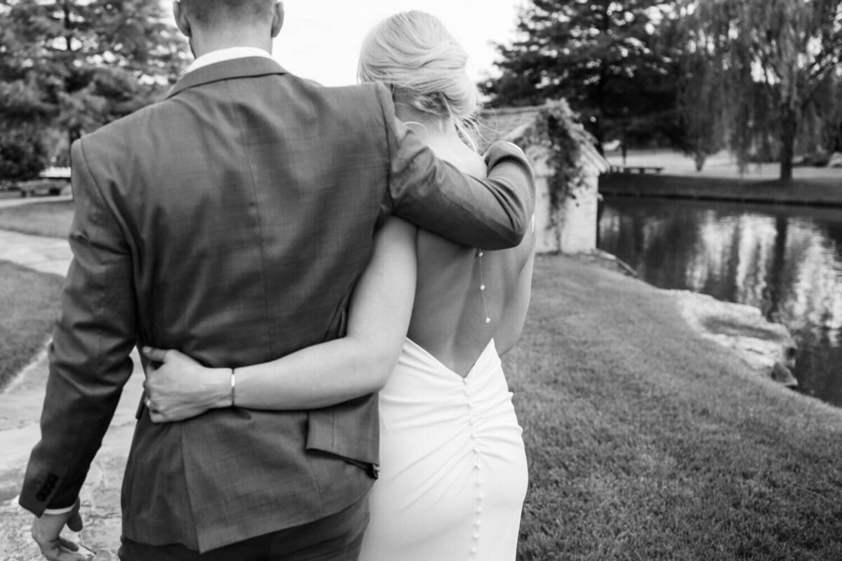 couple-walking-away-next-to-waterfall-pond