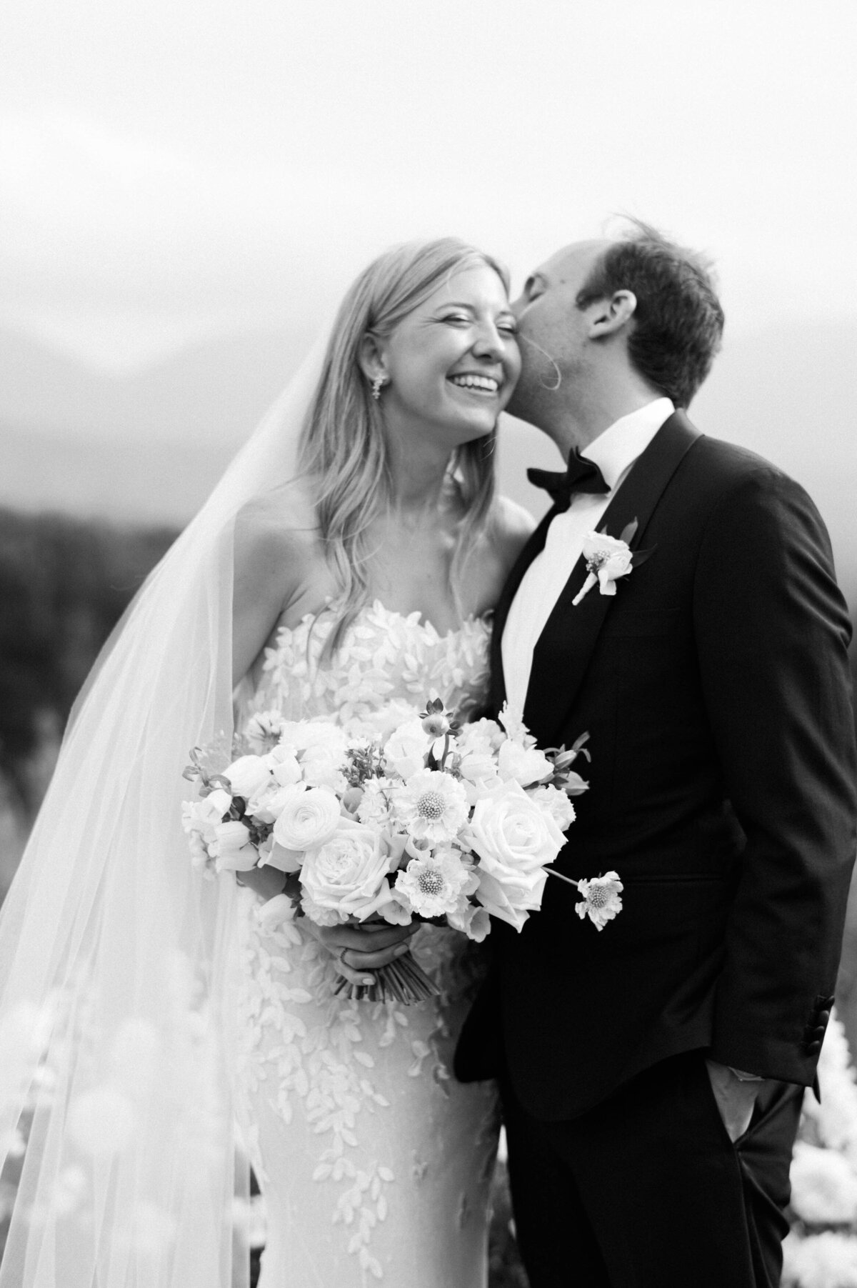 Groom kisses bride on the cheek 