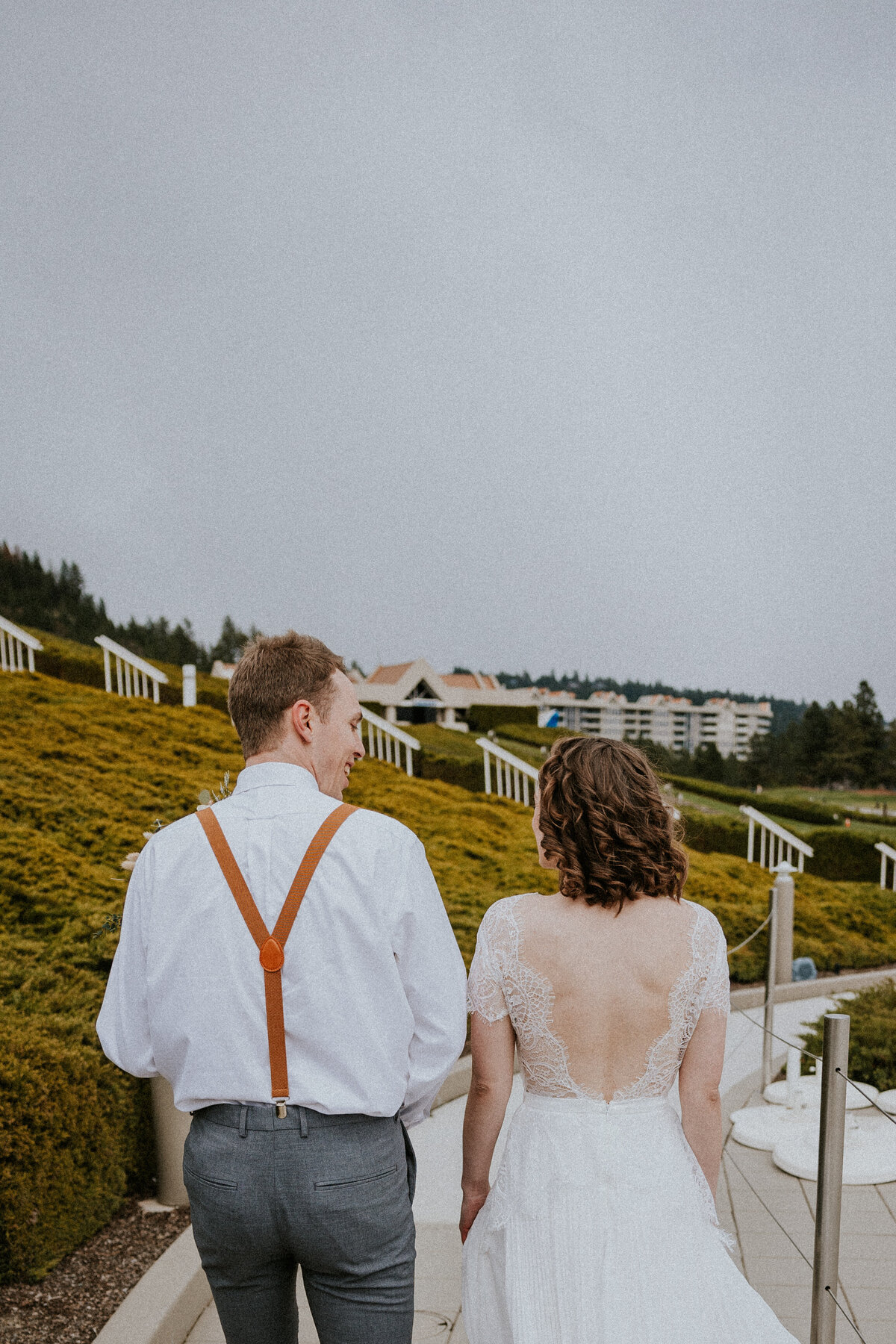 Bride and groom walk up pathway at Coeur d'Alene golf course.