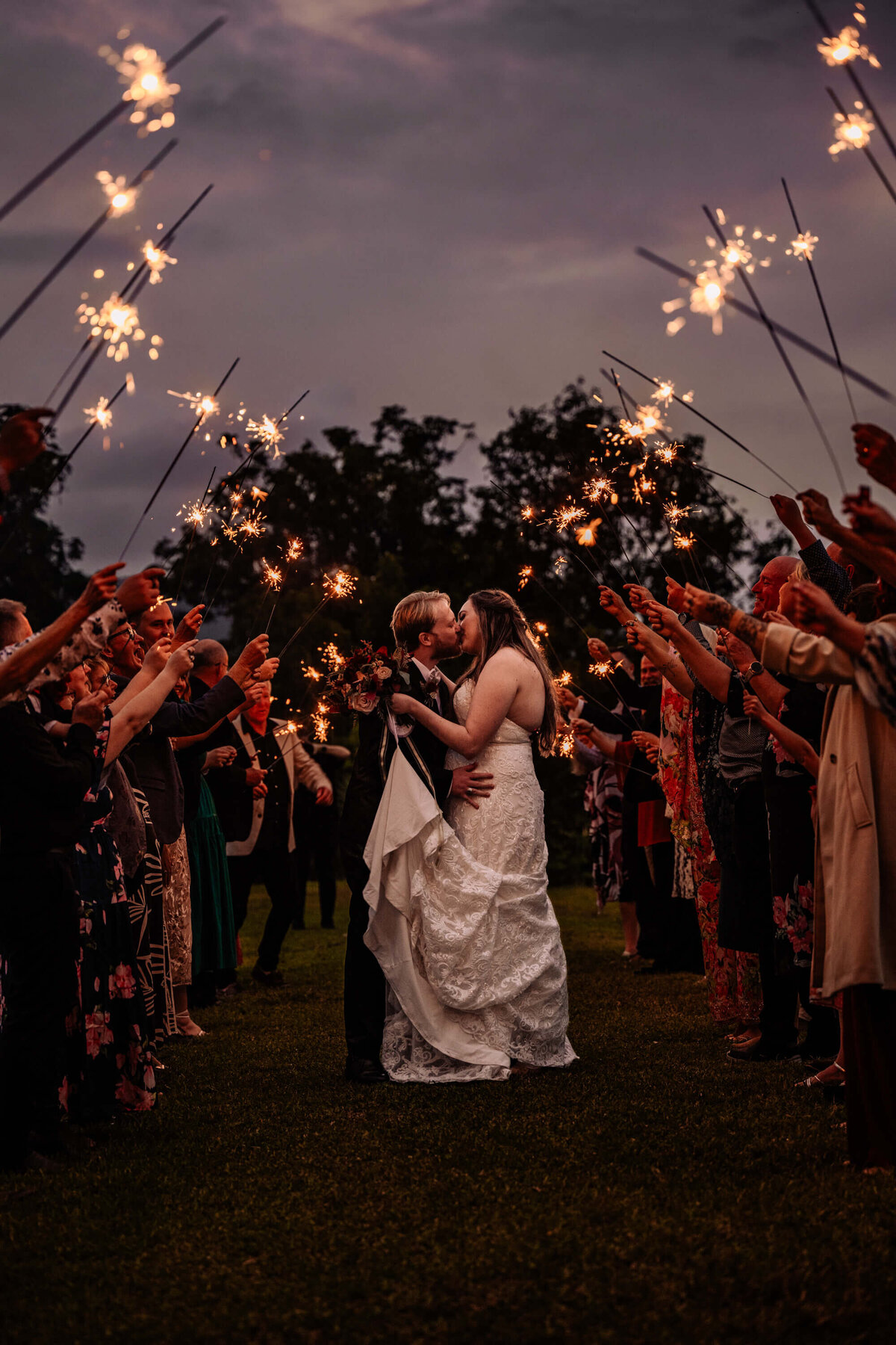 A beautiful display of wedding sparklers illuminating the night sky, creating a magical atmosphere for the celebration. - photo by Jamie Simmons