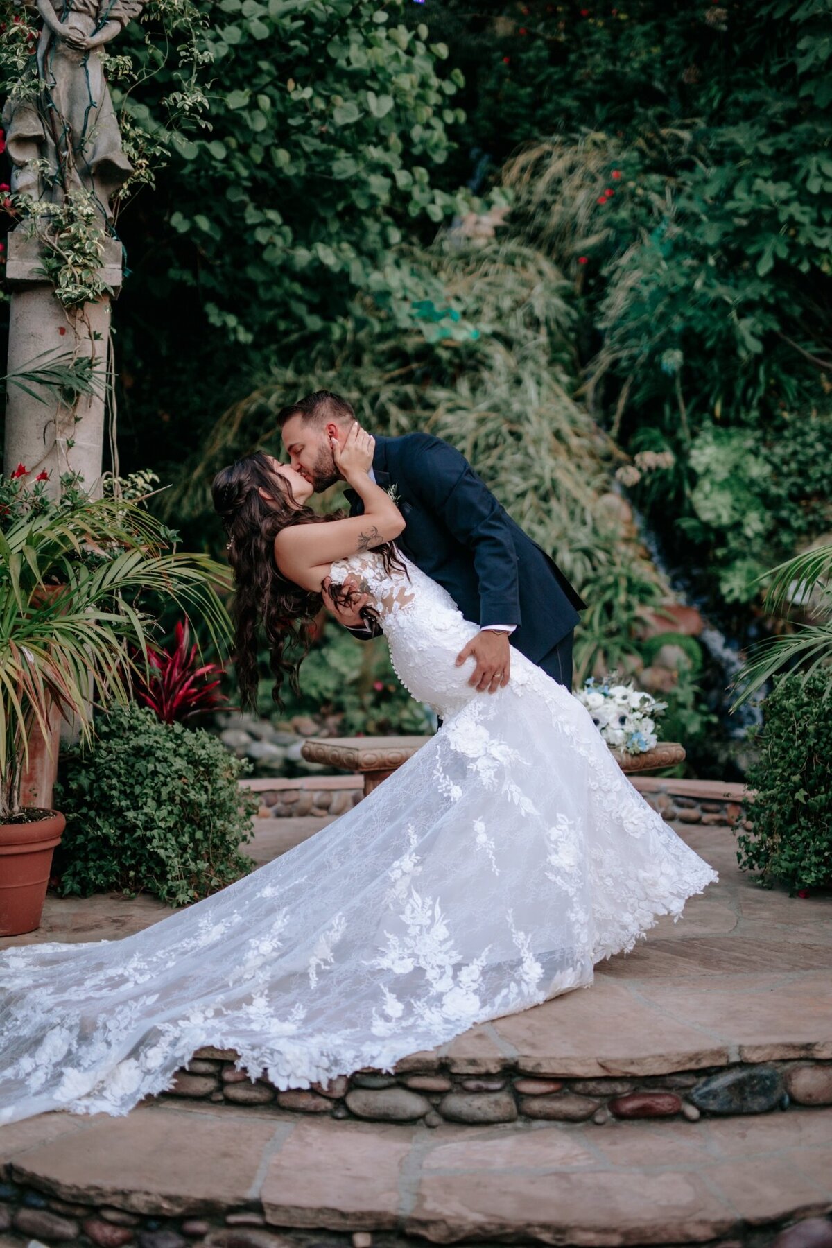 Bride and Groom kissing outside of their Laguna Beach wedding venue  while groom dips bride.