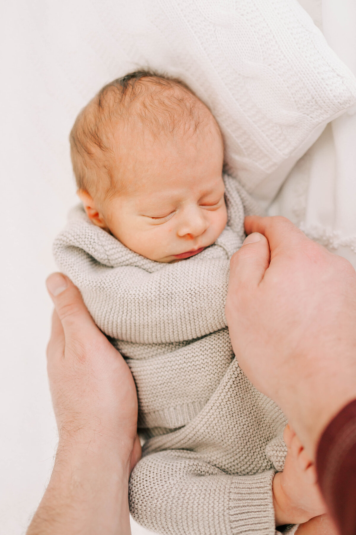 Springfield MO newborn photographer captures baby boy in dads hands