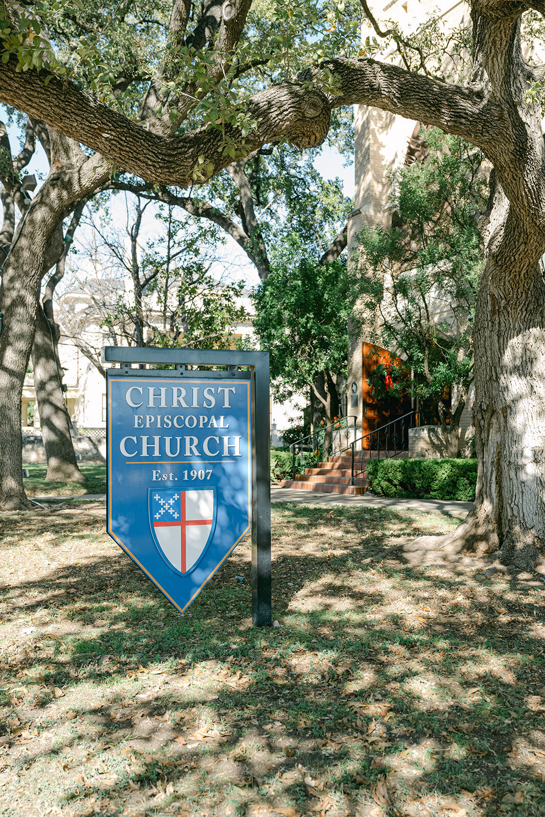 Stylized welcome sign framed by nature outside traditional church wedding venue in San Antonio, Texas