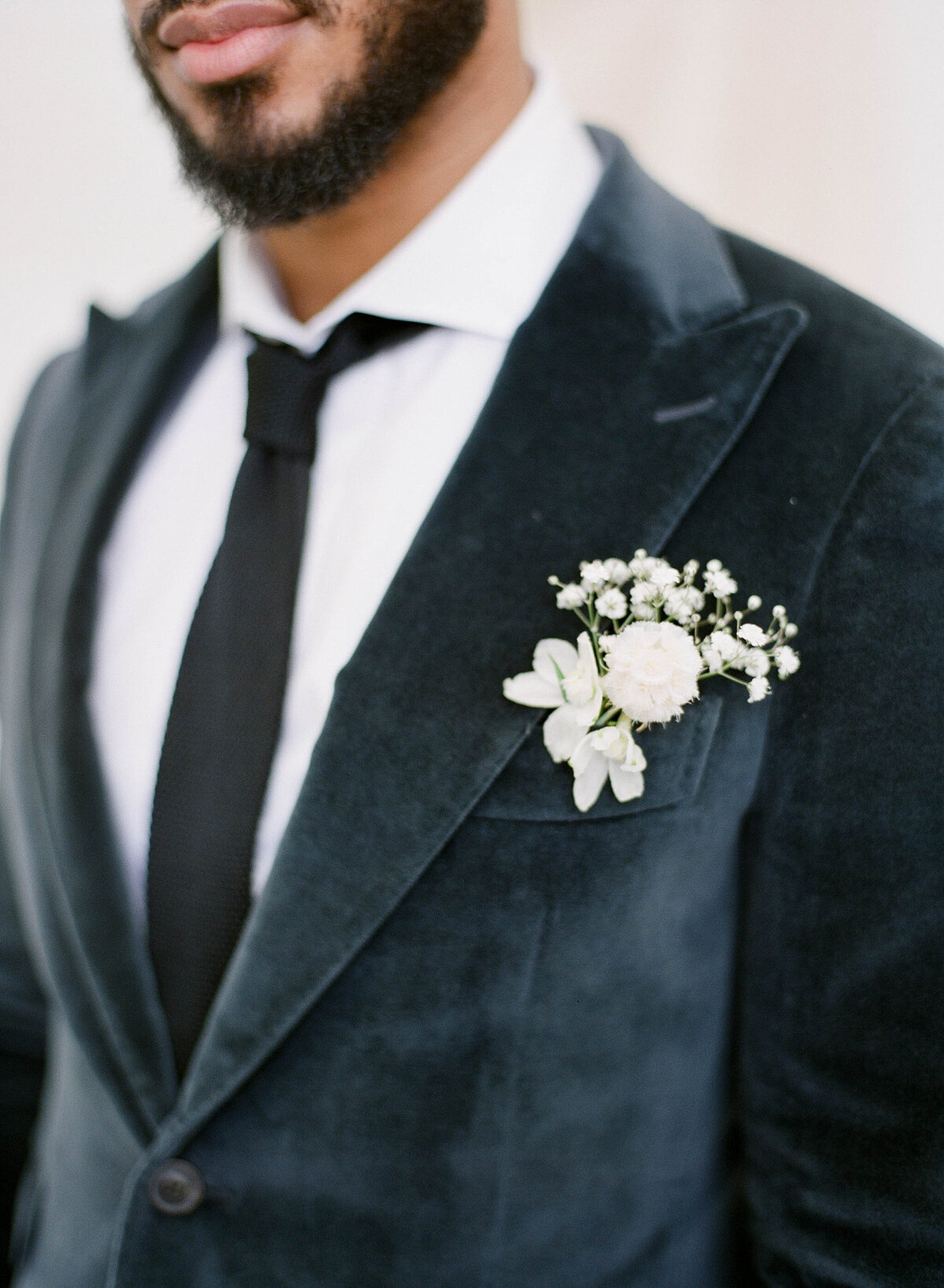 groom with blue velvet suit jacket and boutonniere
