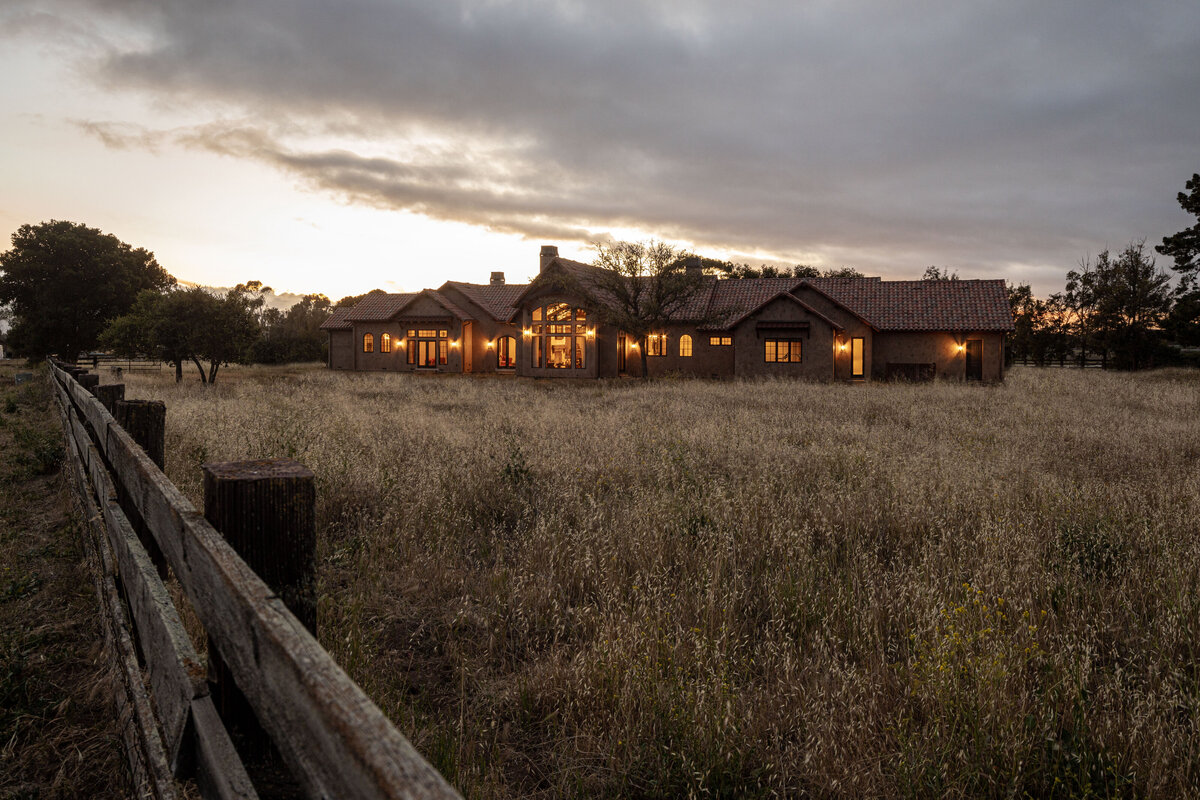 Interior photography of an elegant farmhouse exterior at dusk with warm lights