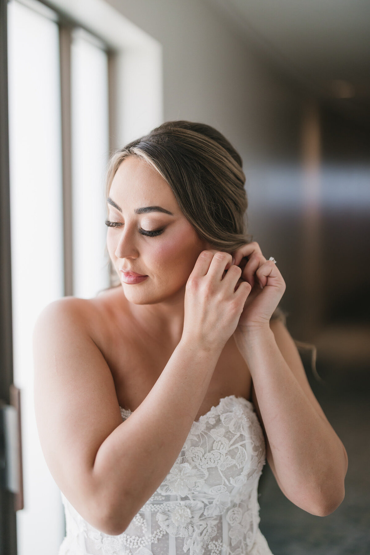 Bride putting on earrings getting ready for wedding day at Hilton Beachfront Resort Santa Barbara in California