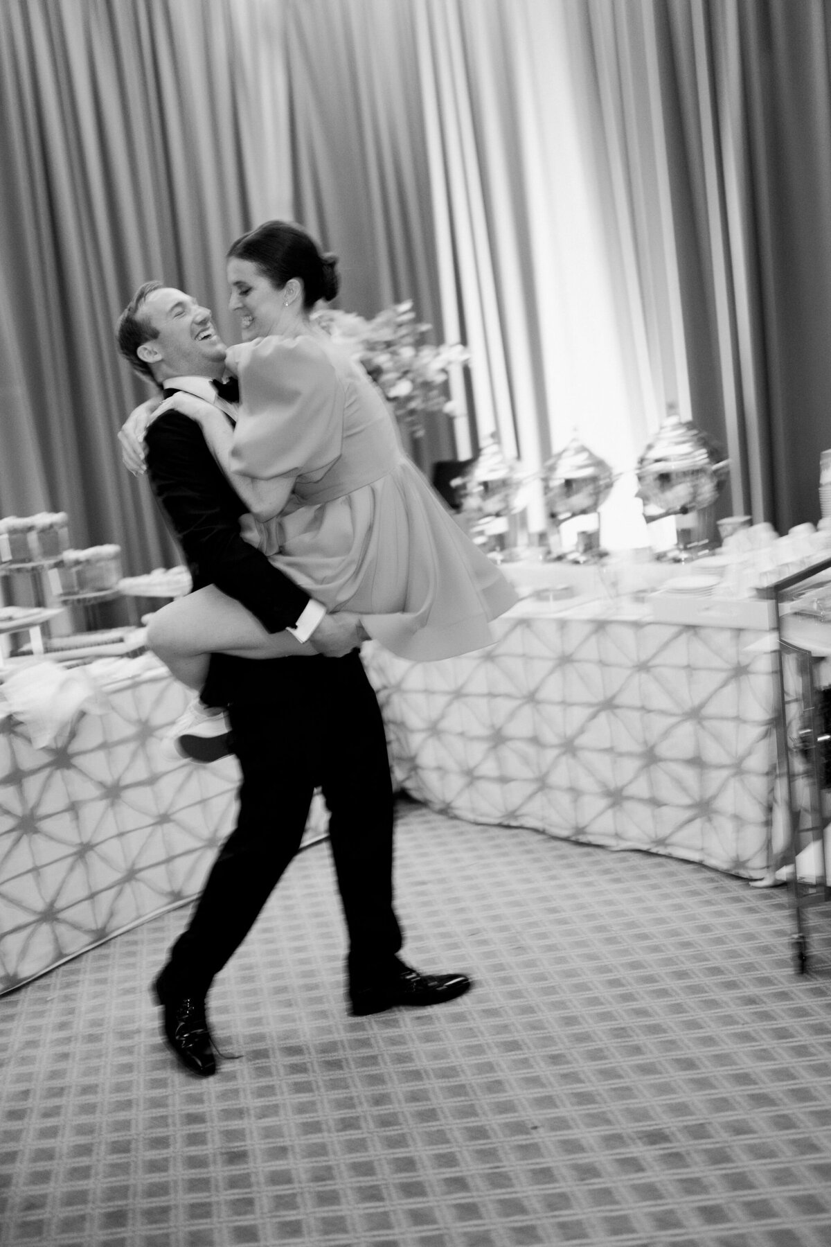 A picture of the groom carrying the bride. 