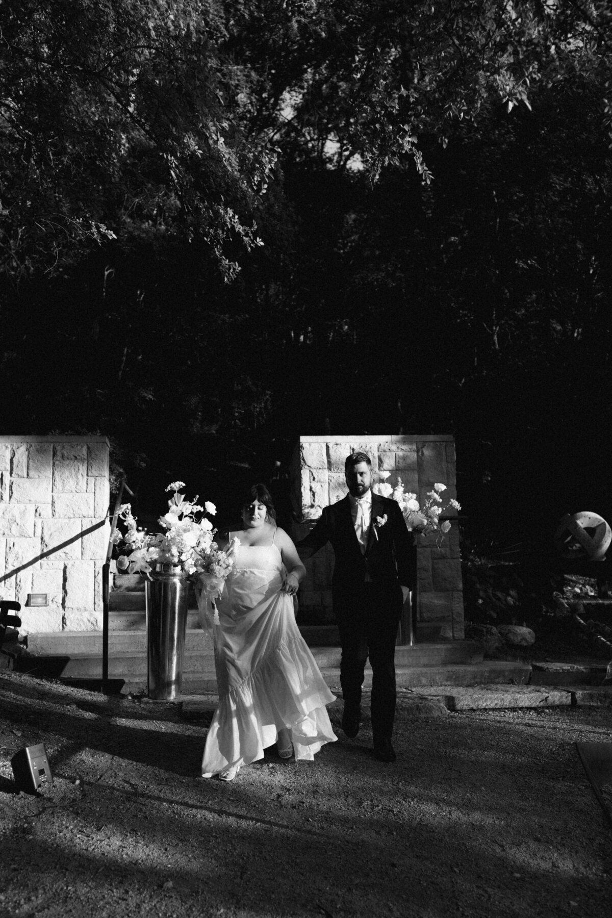 Bride and groom walking in grounds of Couple portraits in the grounds of Umlauf Sculpture Garden, Austin