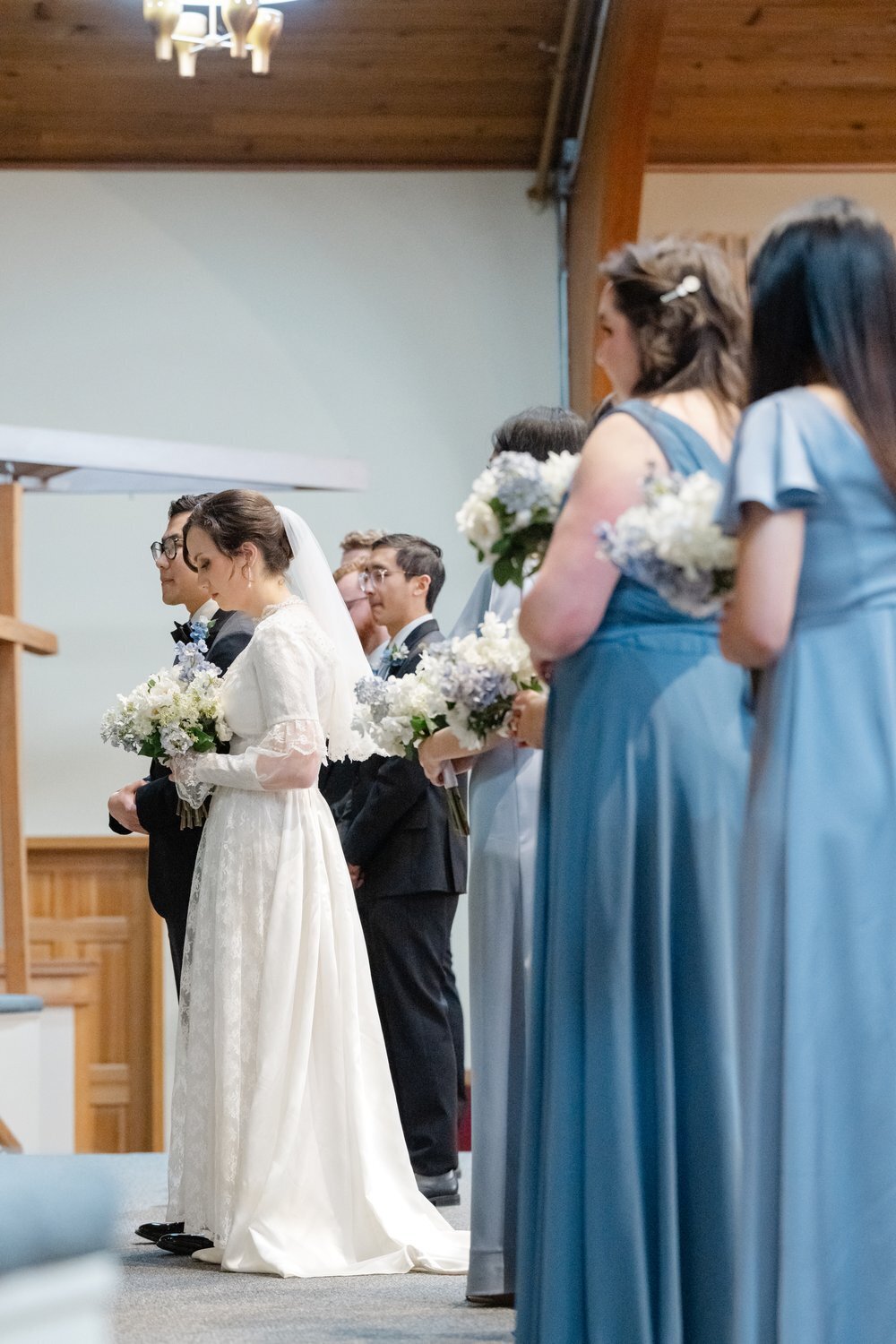 couple and wedding party at front of church during vows