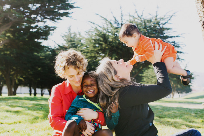 Two women sit and hold babies in a candid shot