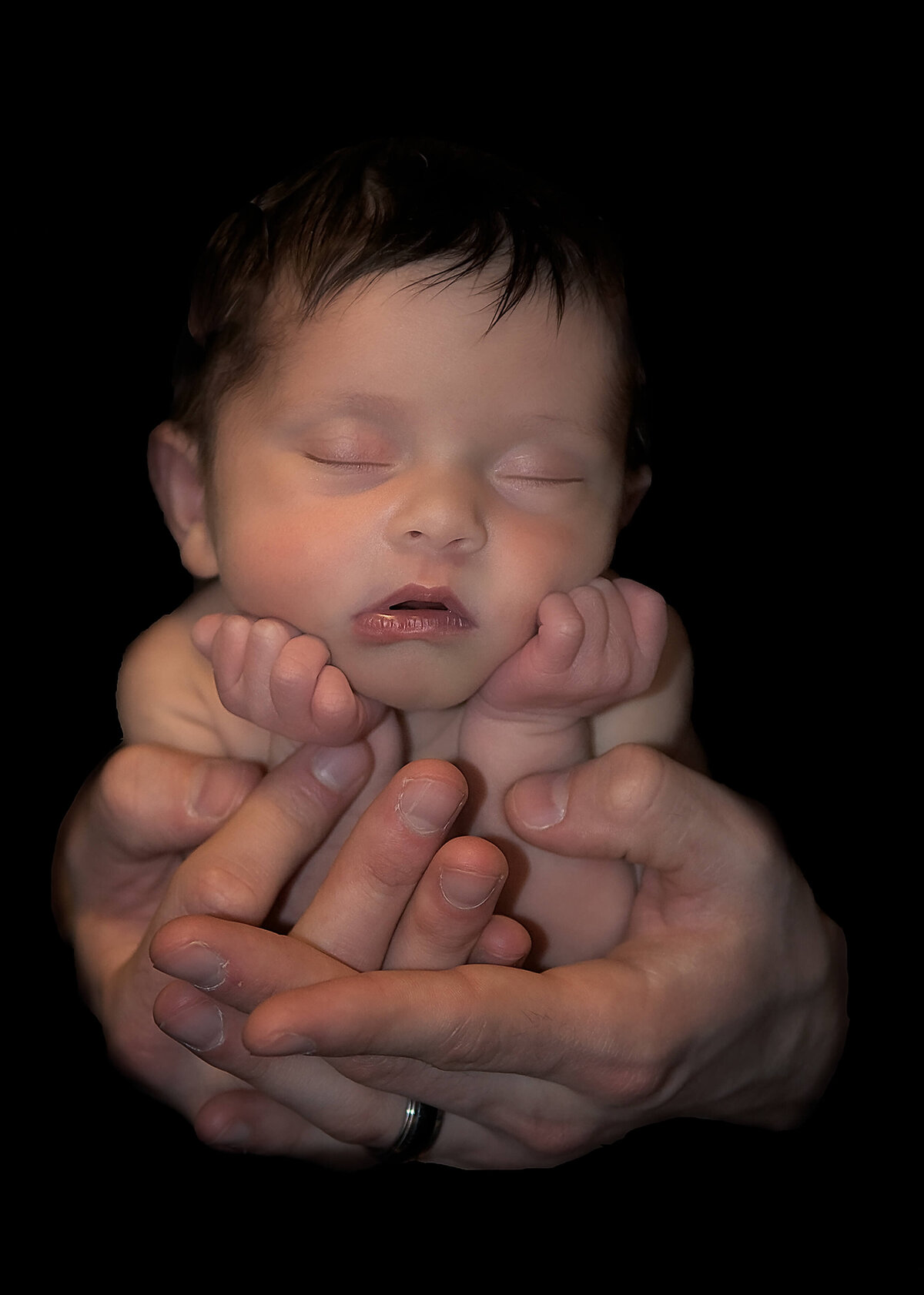 Newborn photo captured by Beth Benecki of a newborn being held by dad's hands