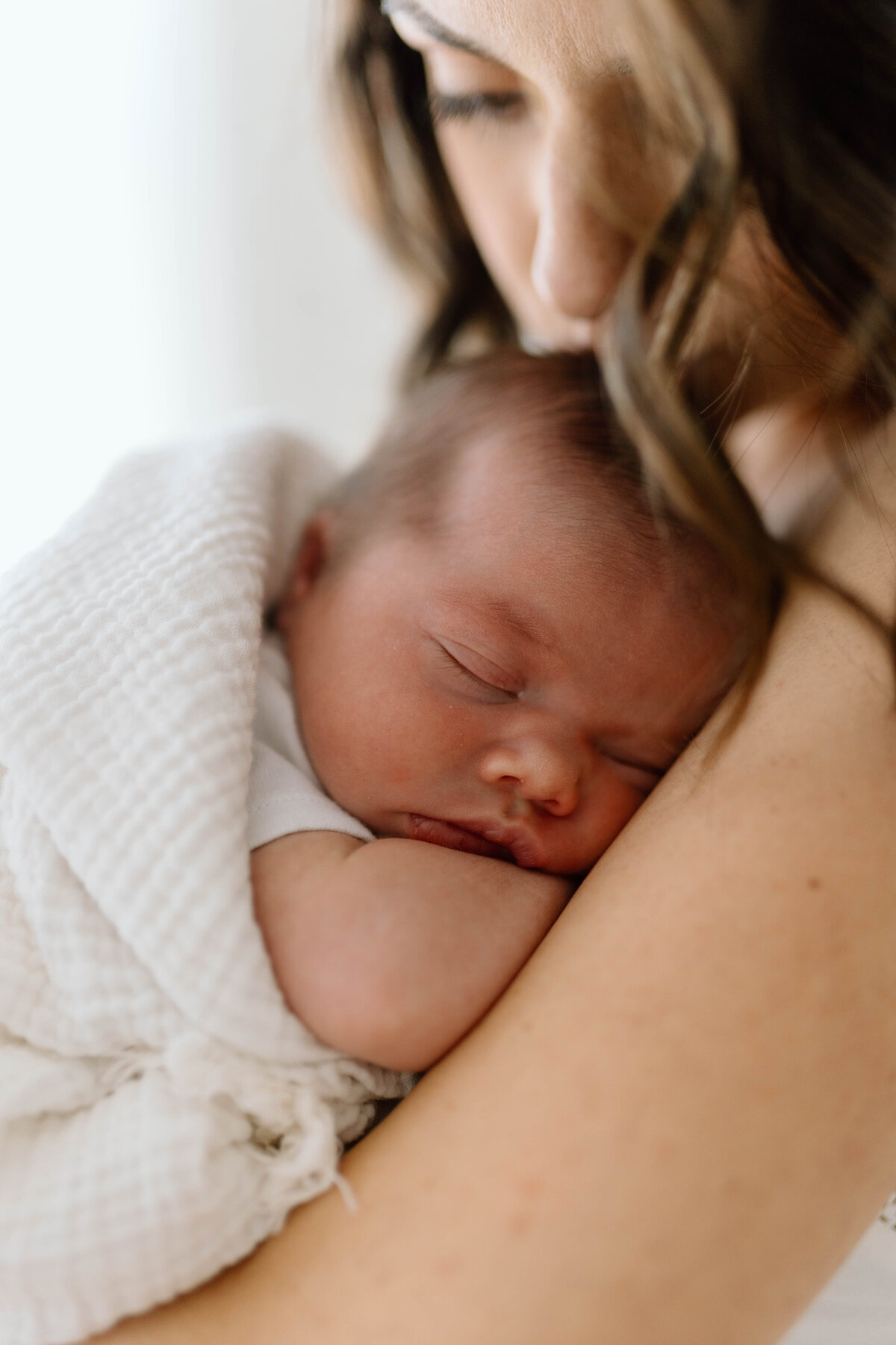 Mother hugging her child during soft, warm family photos