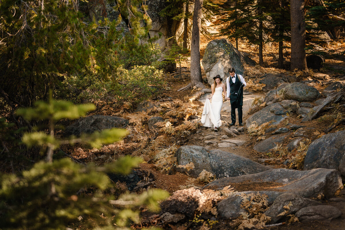 Photographer sonderland.us captures a fun moment of a couple hiking to their ceremony location during an adventure elopement in yosemite, ca