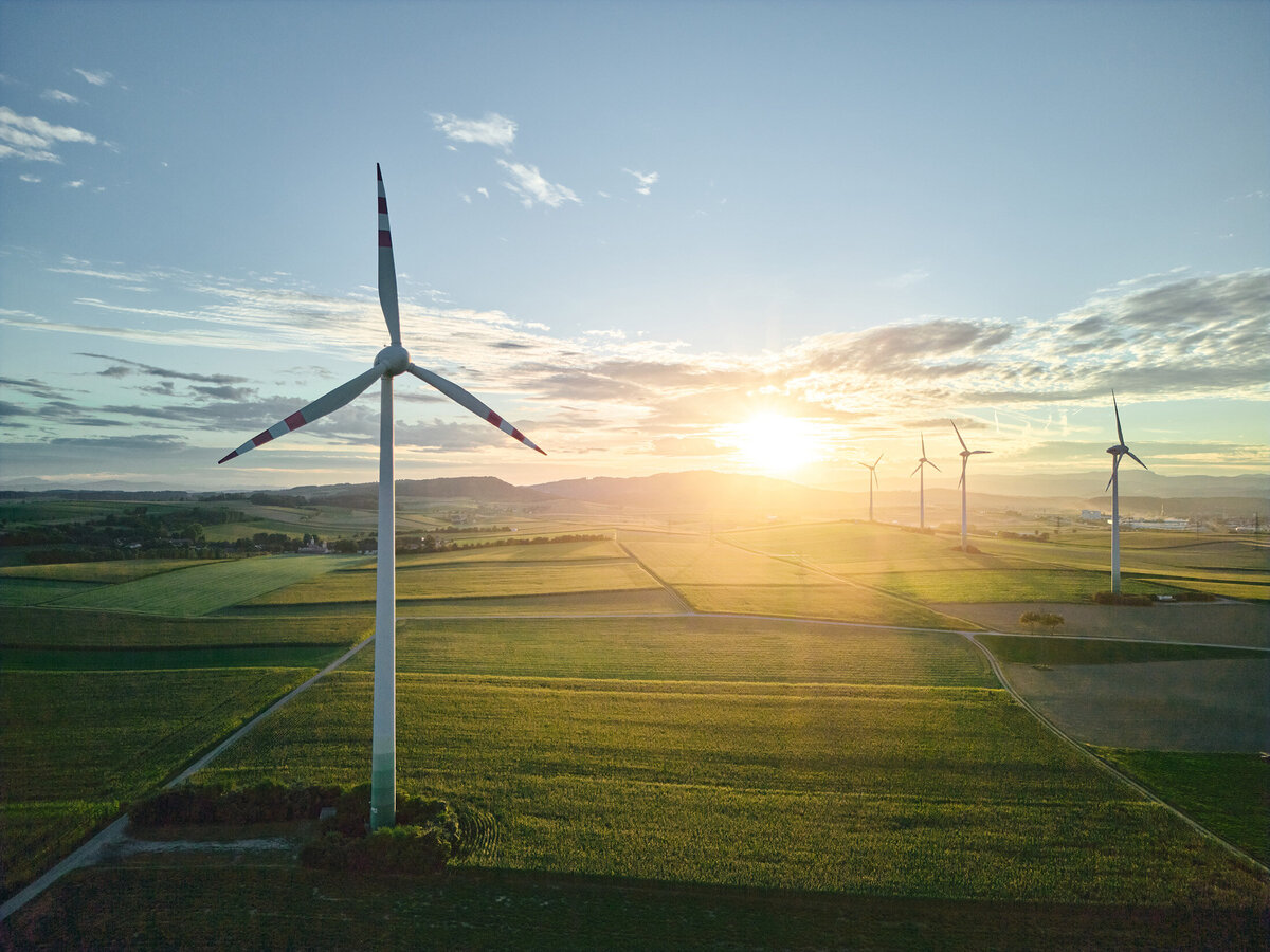 Windräder bei Sonnenuntergang – moderne Landschaftsfotografie mit Fokus auf erneuerbare Energie in Österreich, umgesetzt von Atelier Schulte, Spezialist für Alpenlandschaften und visuelle Konzepte