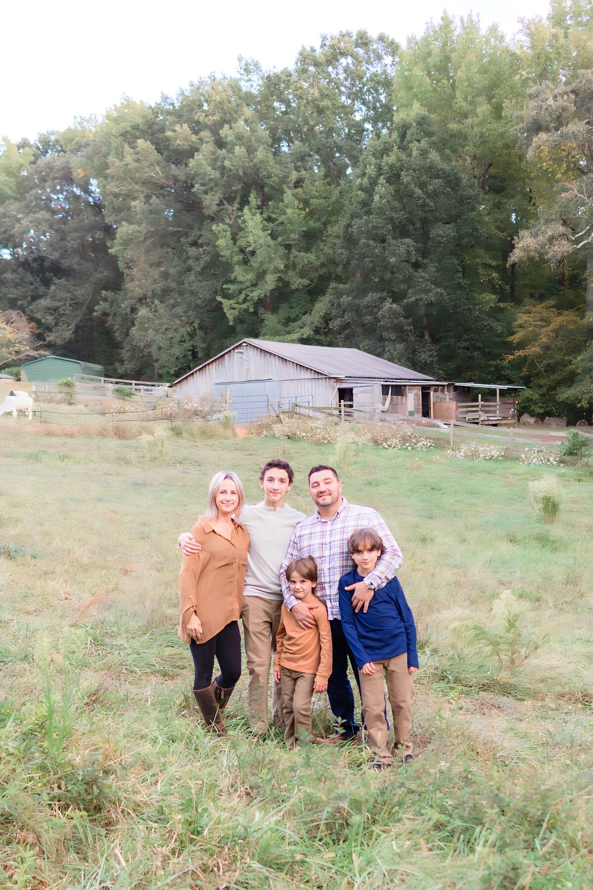 Family embracing in field at a park in Davidson NC