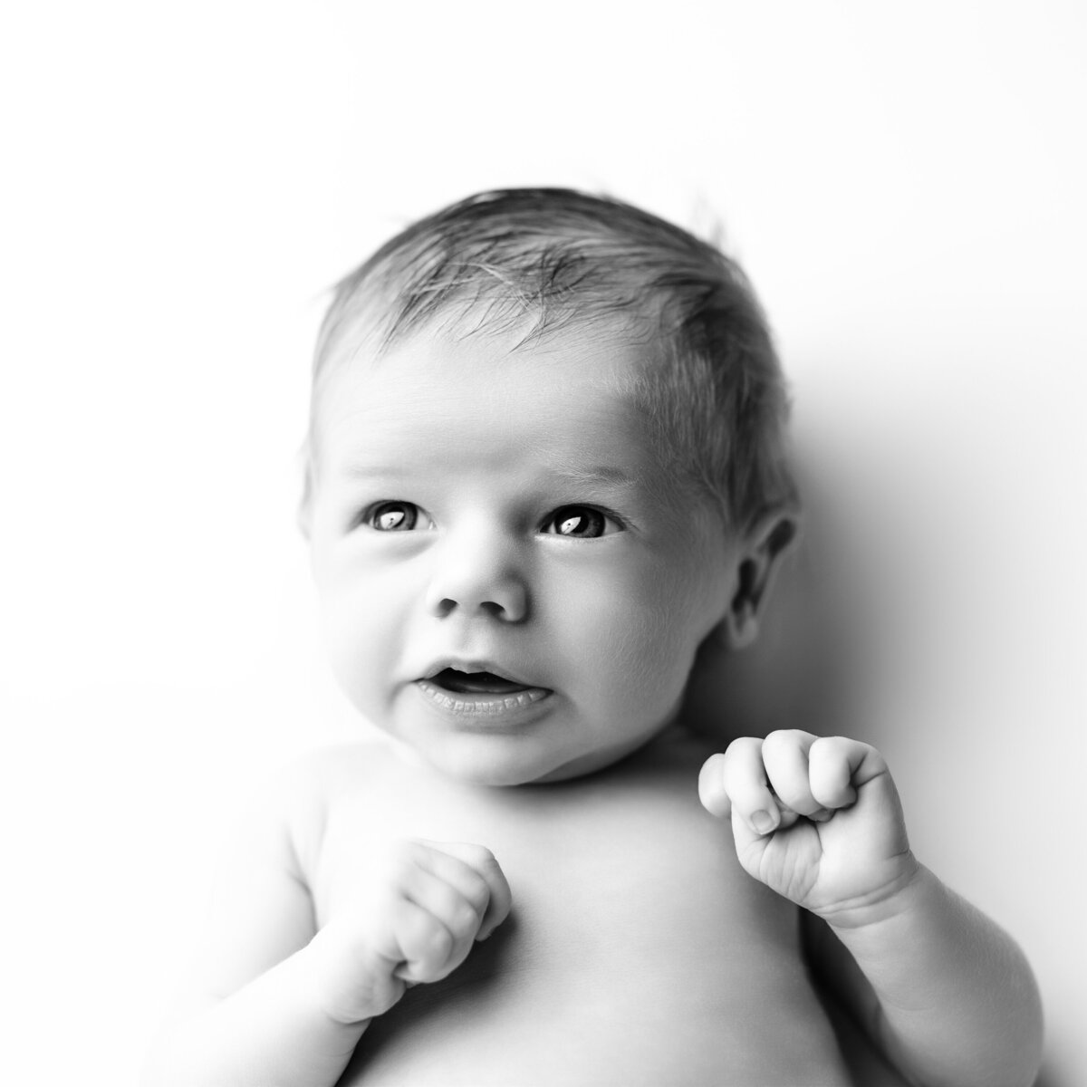 A joyful newborn portrait highlighting bright eyes and a tender expression, perfect for showcasing baby’s emerging personality.