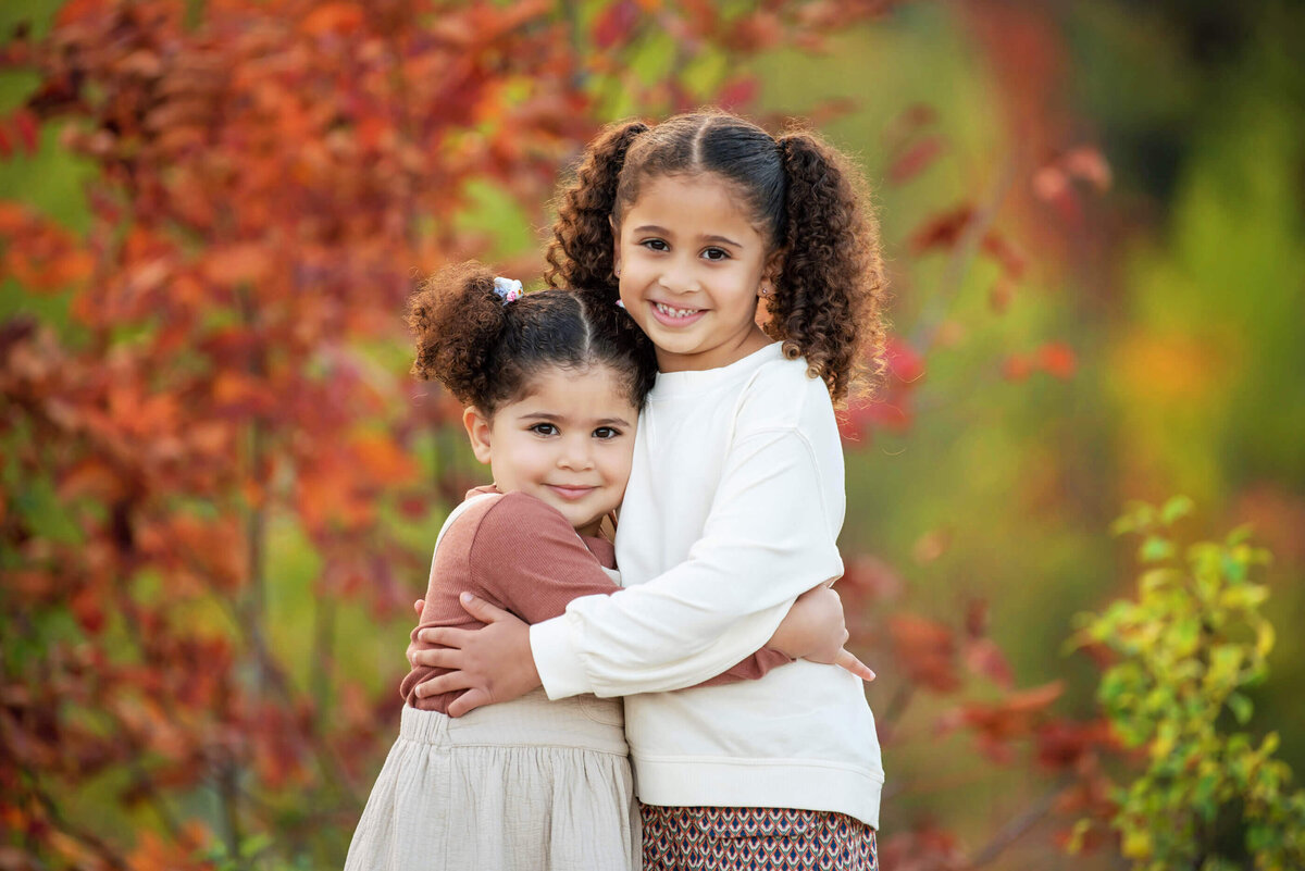 Award-winning photo of sisters hugging for their fall family photography session in Burlington, On